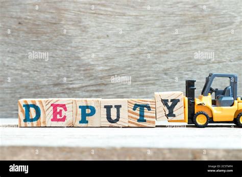 Toy Forklift Hold Letter Block Y To Complete Word Deputy On Wood