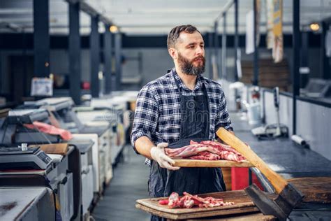 Carnicero Barbudo Que Sirve La Carne Fresca Del Corte Foto De Archivo