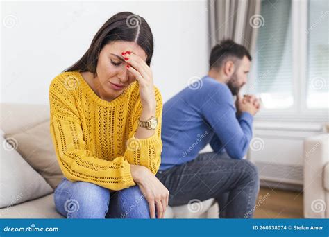 Unhappy Thoughtful Married Couple Spouses Sitting Separately On Couch