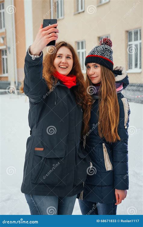 Deux Belles Filles Faisant Le Selfie Sur Le Fond Blanc Image Stock