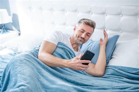 Happy Mature Man In Bed Chatting On Phone Stock Photo Image Of Dial