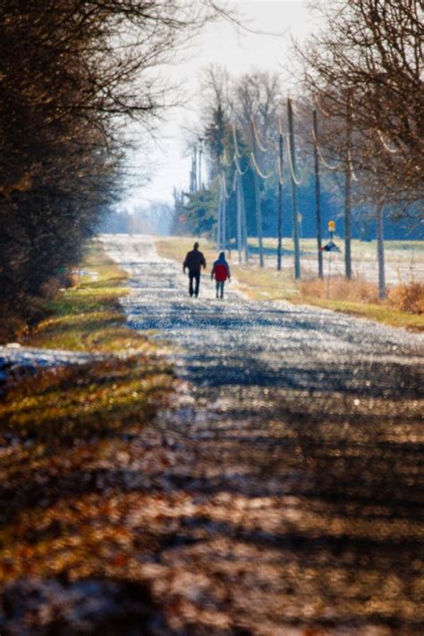 Vertical De Un Padre Con Su Hijo Caminando Por Una Carretera En Un