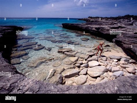 Turks Caicos Islands Providenciales Provo Woman In A Red Bikini Climbing On Rocks In A Cove On