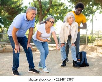 Positive Multiracial Mature People Playing Petanque Stock Photo