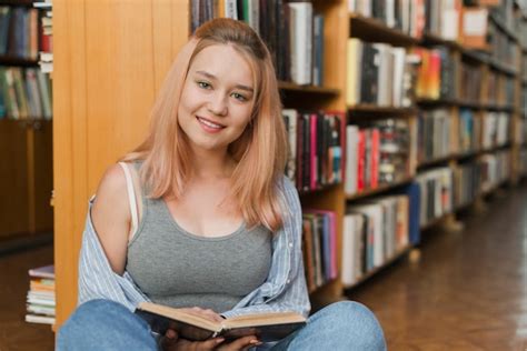 Hermosa Adolescente Con Libro En La Biblioteca Foto Gratis