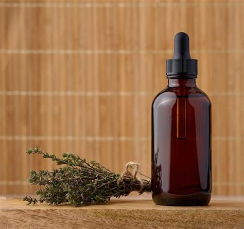 Premium Photo Thyme Essential Oil In Glass Bottle With Dropper And