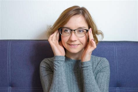 Premium Photo Portrait Of A Young Smiling Woman With Glasses On The Sofa