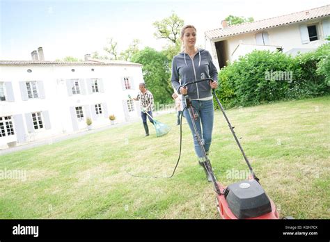 Woman In Garden Mowing The Lawn Stock Photo Alamy