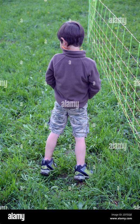 Un petit garçon se papas contre la clôture Photo Stock Alamy