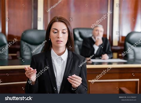 Brunette Prosecutor Pointing Finger During Speech Stock Photo