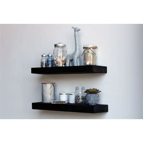 Two Black Shelves With Jars Candles And Other Items On Them Against A