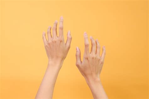 Premium Photo Woman Hands In The Air Over Yellow Background