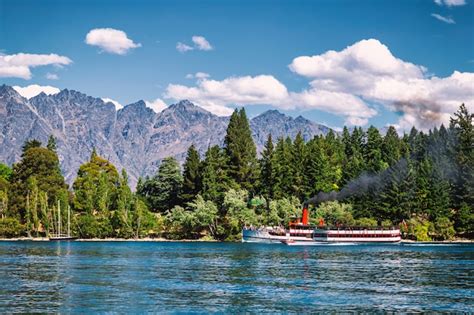 Barco a vapor en el lago wakatipu rodeado de bosques de coníferas en