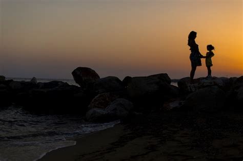 Premium Photo Mother And Daughter At The Beach At Sunset