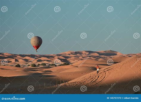 A Hot Air Balloon Flying Over The Desert Stock Photo Image Of Sunlight Arab