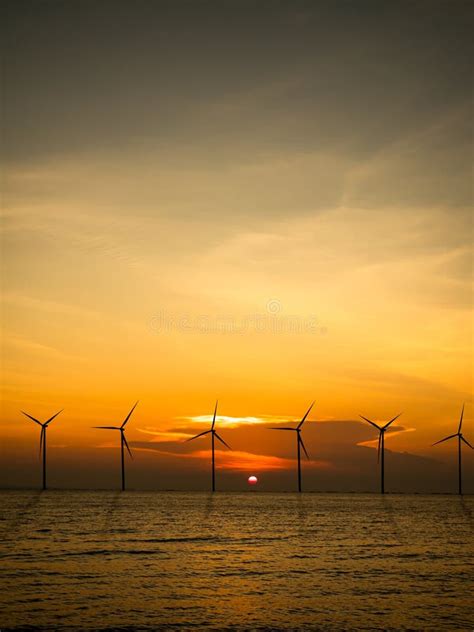 Wind Mill Turbine On Sea Offshore Farm Energy Windmill Sustainable With Red Sunset Ocean