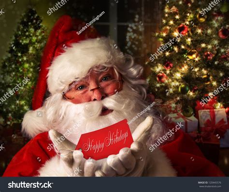 Santa Claus Holding Gift Card With Festive Holiday Background Stock