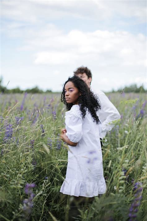 Man In White Suit Jacket And Woman In White Long Sleeve Shirt Standing