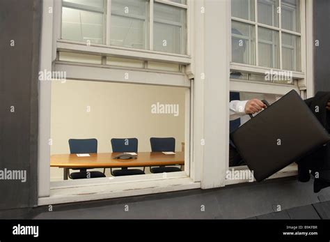 Businessman Leaving Office Building Through Window Stock Photo Alamy