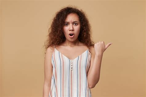 Free Photo Amazed Young Pretty Long Haired Curly Female With Casual