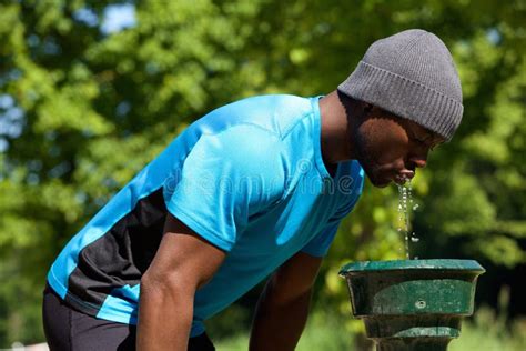 Young Man Drinking Water In A Fountain Stock Photo - Image of park, cute: 20652718