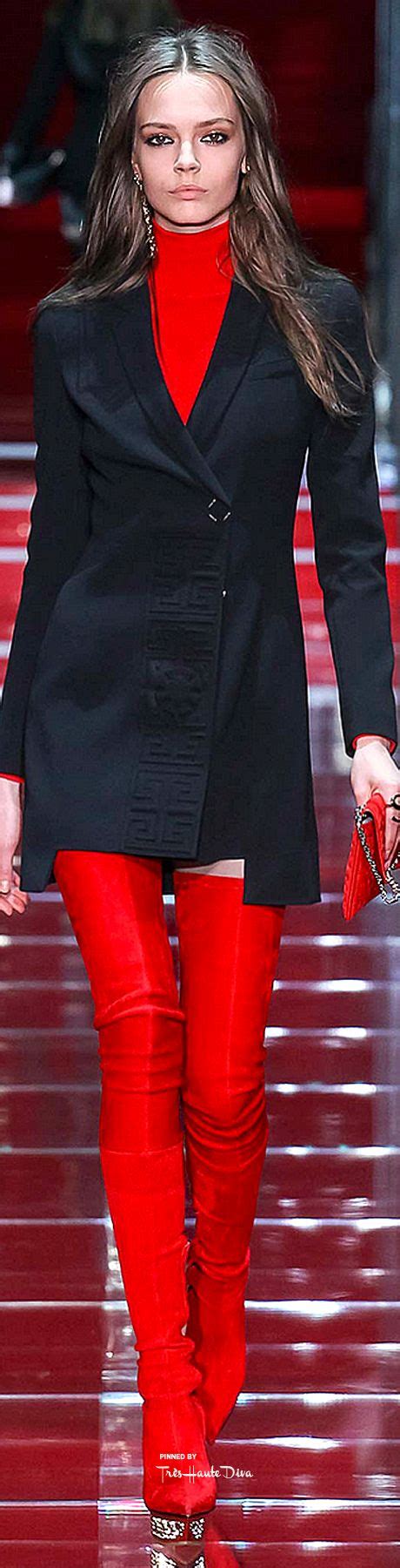 A Model Walks Down The Runway In Red Pants And Black Jacket With Her