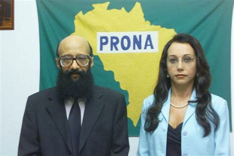 Two People Standing Next To Each Other In Front Of A Green And Yellow