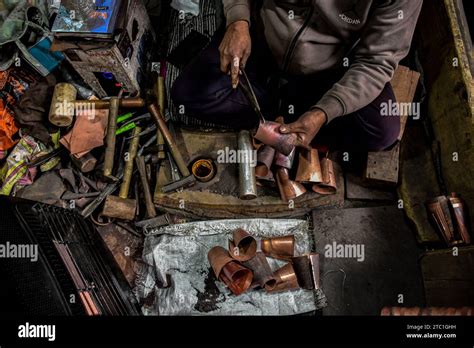 Un Kashmiri Coppersmith Travaille Sur Un Verre De Cuivre Dans Un