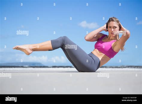 Focused Fit Blonde Doing Yoga On The Beach On A Sunny Day Stock Photo