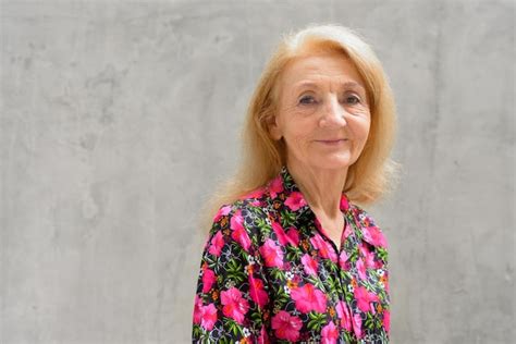 Premium Photo Portrait Of Smiling Woman Standing Against Wall