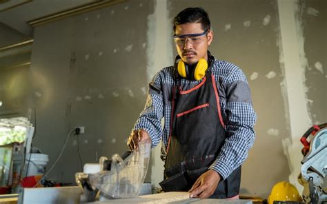 El Carpintero Trabaja En Tablones De Madera En El Taller El Trabajador