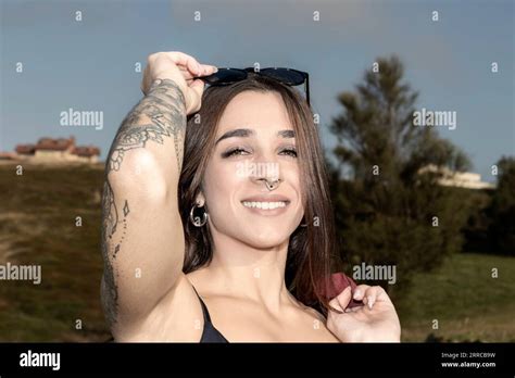 Radiant Beauty Brunette Woman With Piercings And Tattoos Removing Her