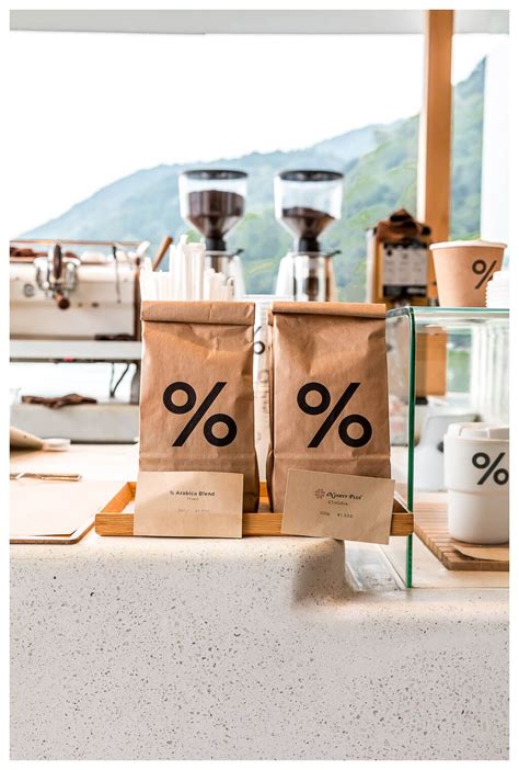 Two Brown Bags Sitting On Top Of A Counter Next To Coffee Grinders And Cups