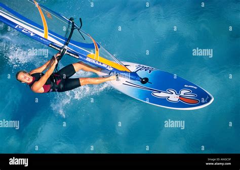 Aerial View Of Shouting Single Female Windsurfer Sailing On Light Blue