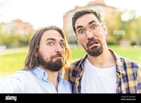 Funny Gay Couple Looking At Camera Making Grimaces In Park Stock Photo Alamy