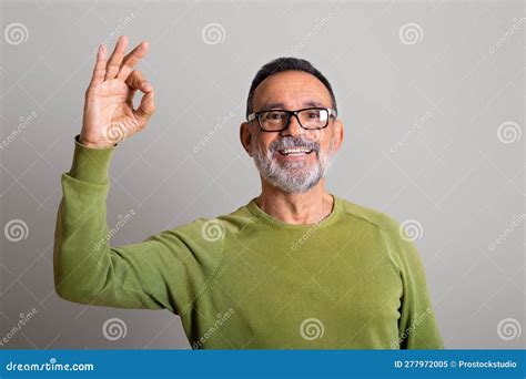 Portrait Of Positive European Old Man In Glasses Shows Ok Sign With