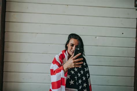 Premium Photo Woman Wearing American Flag Using Phone Against Wall