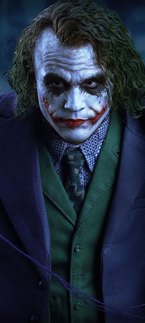 The Joker Is Dressed In A Suit And Tie