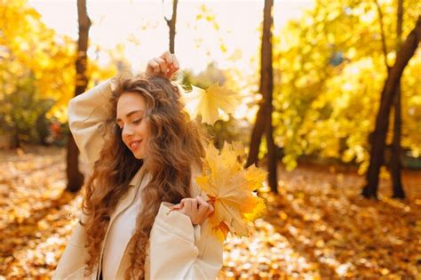 Premium Photo Smiling Young Woman Holds Yellow Leaf In Her Hand In