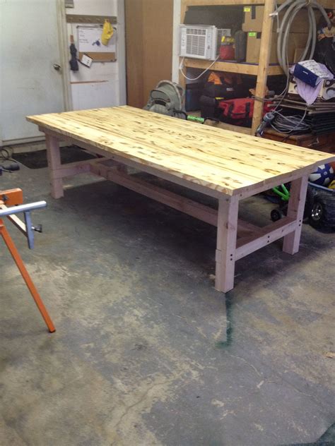 A Table Made Out Of Pallet Wood In A Garage With Tools On The Floor