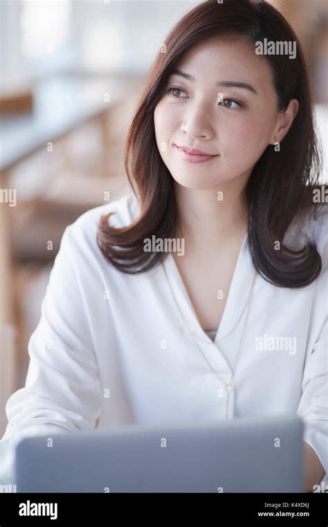 Japanese Woman With Laptop In A Stylish Cafe Stock Photo Alamy