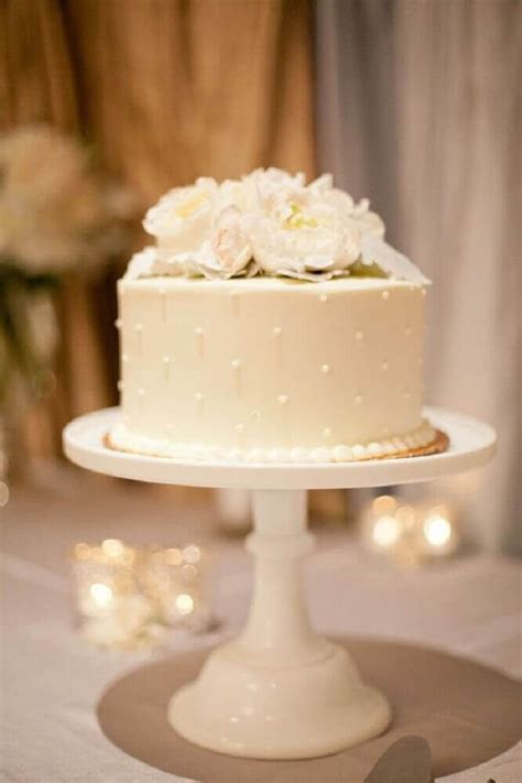 A Wedding Cake With White Flowers On Top