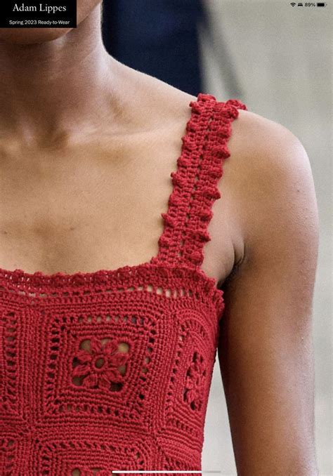 A Woman Wearing A Red Crocheted Dress With An Open Shoulder And Square