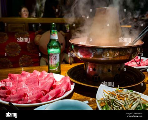 Mongolian Hotpot With Meat Slices Served At Restaurant Table With Local