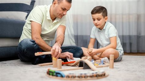 Padre E Hijo Jugando Con Juguetes En El Dormitorio Foto Gratis