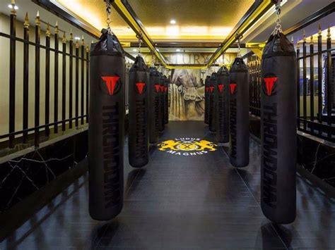 An Indoor Gym With Punching Bags In The Middle