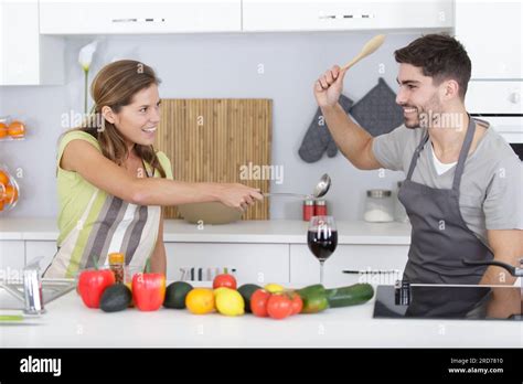 Funny Couple Pretending Fight With Utensils Tools While Cooking Stock