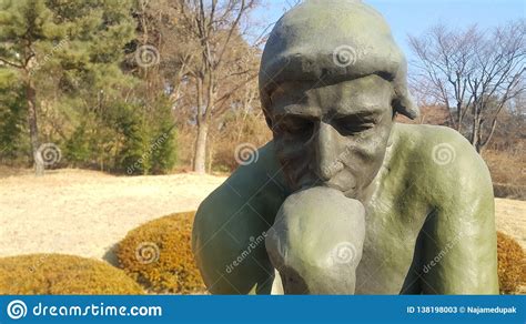 Green Statue Of Thinker Auguste Rodin Setting Naked On A Rock