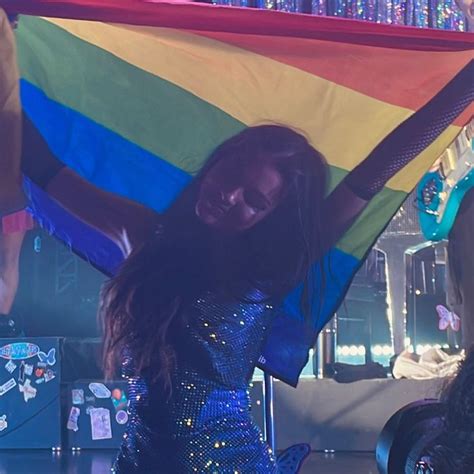 A Woman Holding A Rainbow Flag In Her Hands