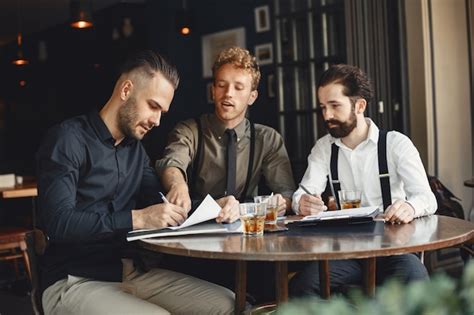 Empresarios En Negociaciones Hombres Con Alcohol Sentados A La Mesa